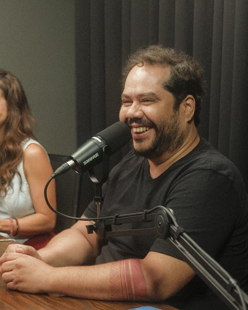 Ator Pedro Benevides gravando podcast de comédia. Estúdio com cadeiras ergonômicas e conforto para hosts e convidados.