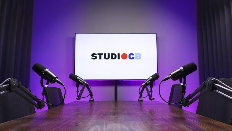 Estúdio de podcast com TV de 55 polegadas para exibir sua logo e patrocinadores. Branding profissional na Barra da Tijuca.